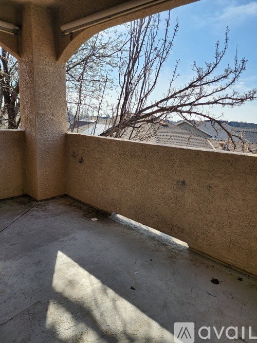 A balcony with a view of a tree and a building.