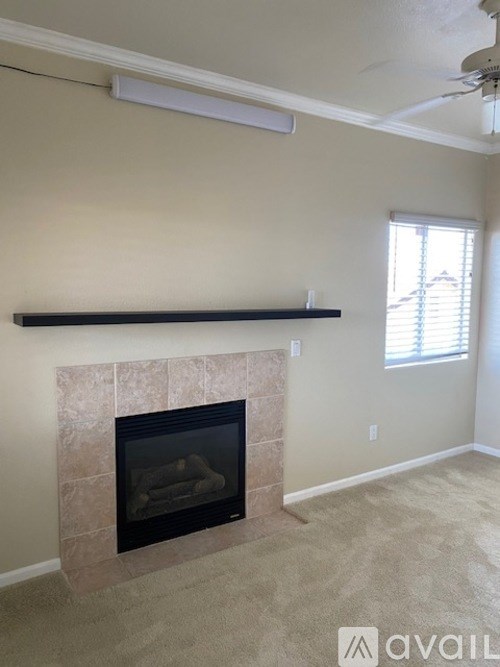 A living room with a fireplace and a window.