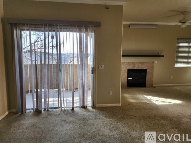 A room with a fireplace and a sliding glass door.