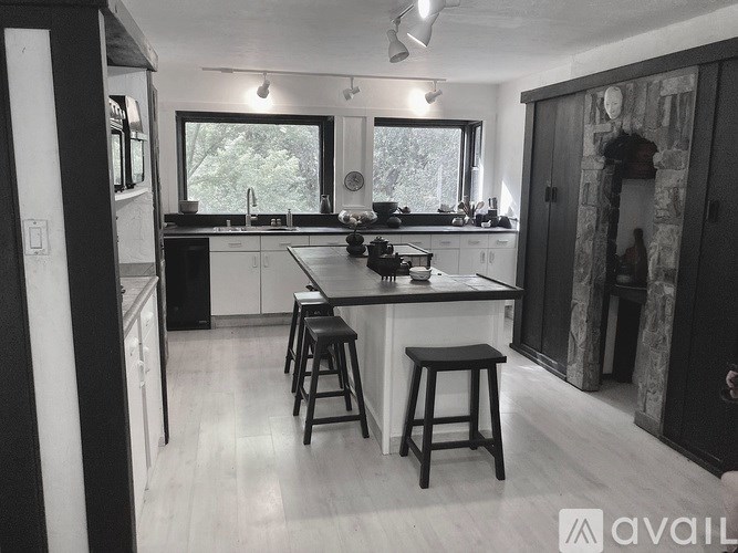 A kitchen with white cabinets and a black countertop.