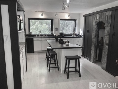 A kitchen with white cabinets and a black countertop.