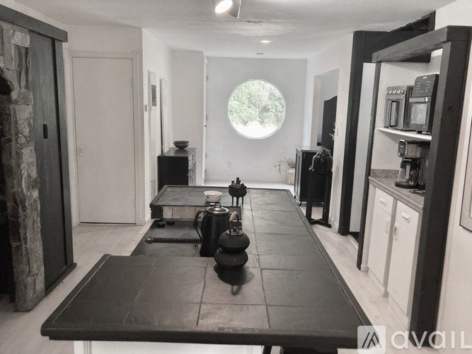 A black and white photo of a kitchen with a table and chairs.