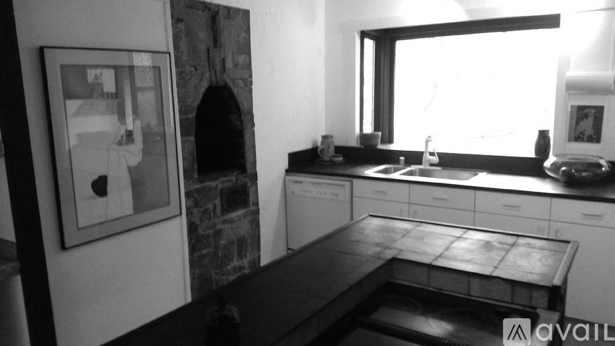 A black and white photo of a kitchen with a washing machine and a fridge.
