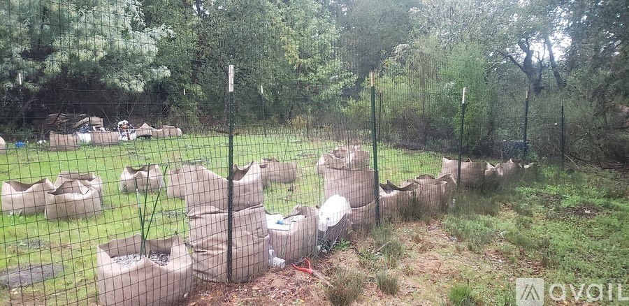 A fenced area with several concrete structures in the foreground.