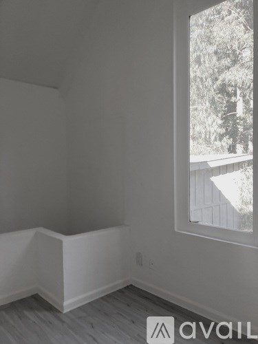 A room with a window and wooden flooring.