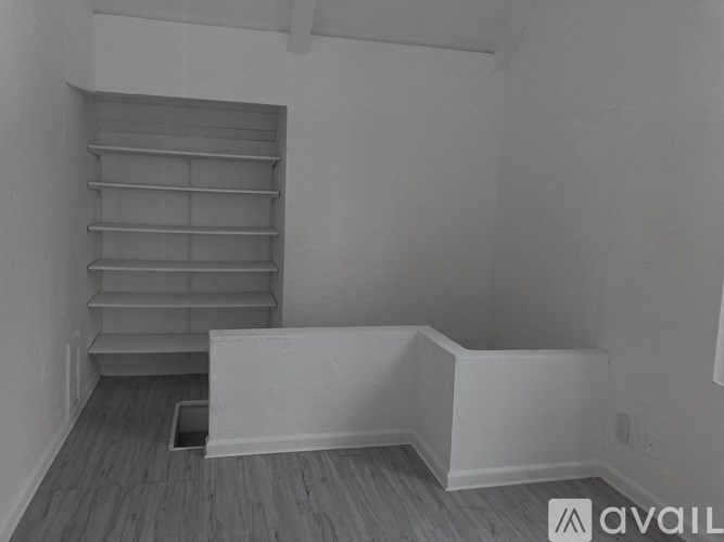 A room with a staircase and a hole in the floor.