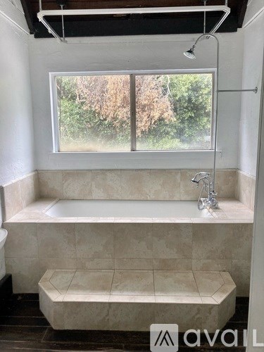 A bathroom with a large window and a bathtub.