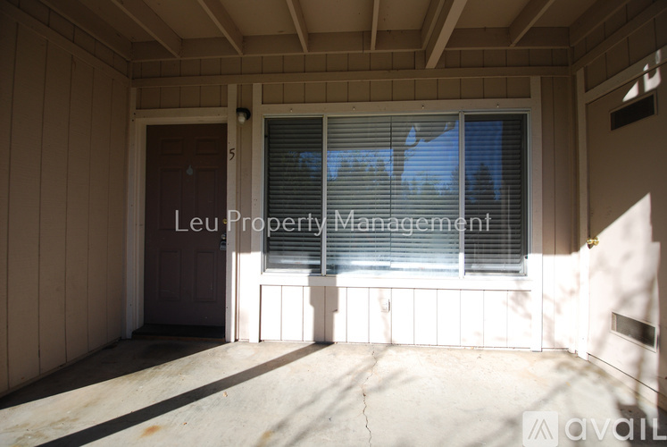 A room with a window and a door, managed by Leu Property Management.