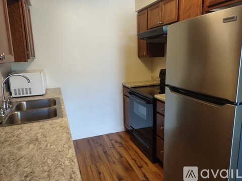 A kitchen with a sink, stove, and refrigerator.