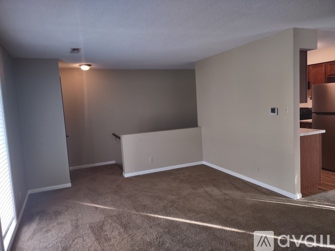 A room with a carpeted floor and a white wall.
