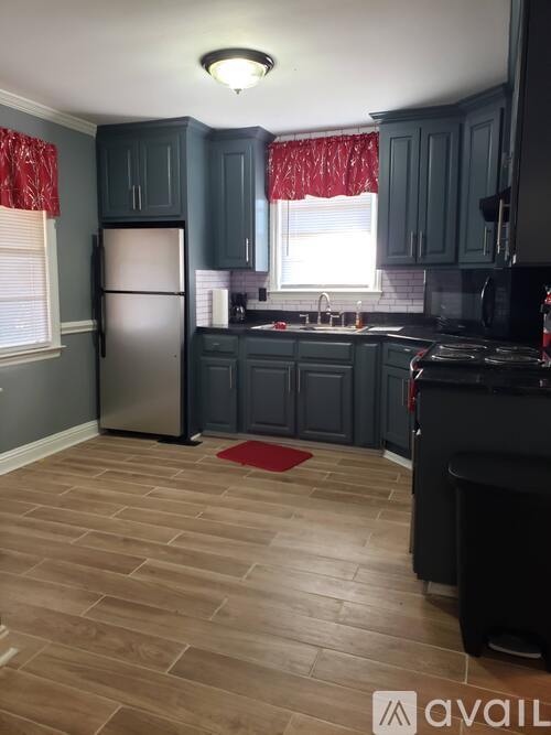 A kitchen with dark wood cabinets and a refrigerator.