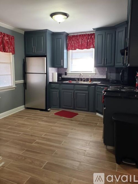 A kitchen with dark wood cabinets and a refrigerator.