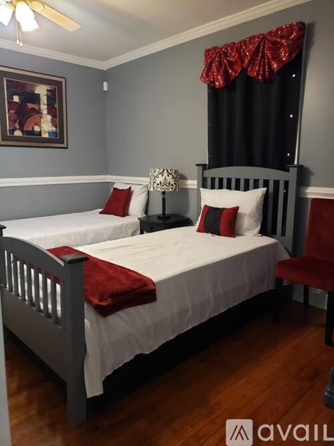 A bedroom with a bed, pillows, and a ceiling fan.
