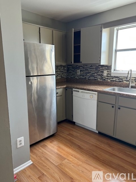 A kitchen with a stainless steel refrigerator and a white dishwasher.