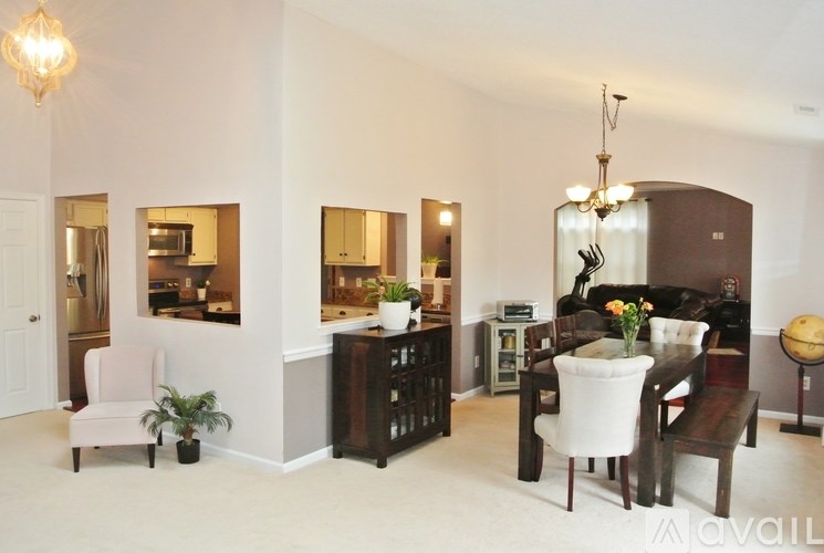 A living room with a white sofa and a wooden dining table.