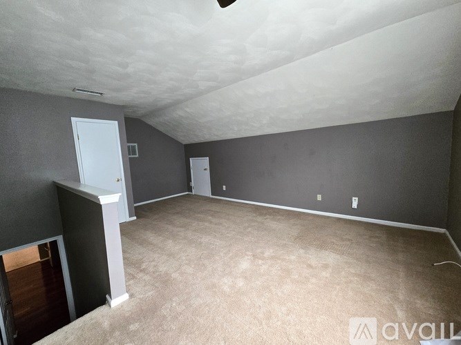 A bedroom with a bed, chair, and dresser.