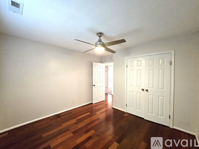 A hallway with wood floors and white doors.