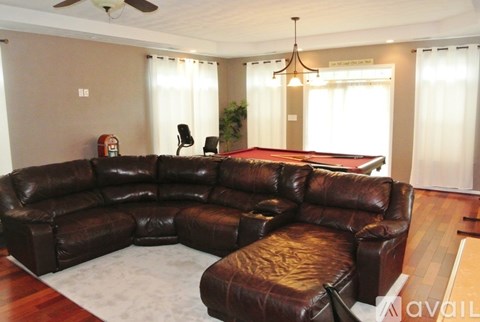 A brown leather sectional sofa with a chaise lounge in a living room.