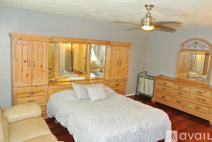 A bedroom with a bed, dresser, and mirror.