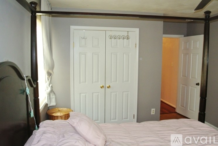 A bedroom with a four poster bed and a white door.