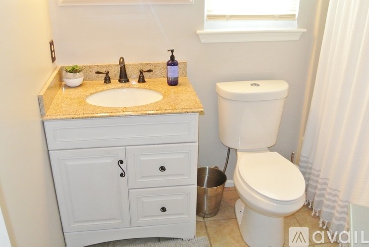 A bathroom with a sink, toilet, and a white cabinet.