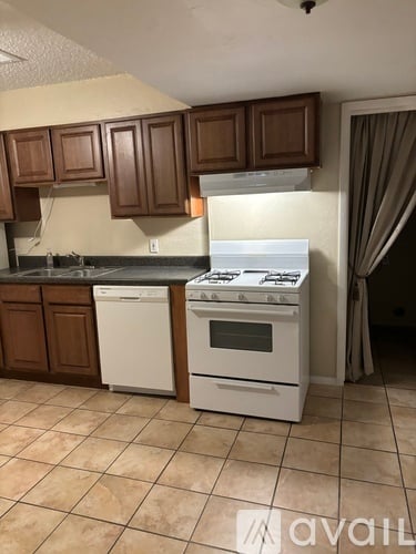A kitchen with a white stove and brown cabinets.