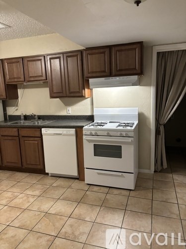 A kitchen with a white stove and brown cabinets.