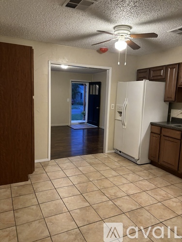 A kitchen with a white refrigerator and brown cabinets.