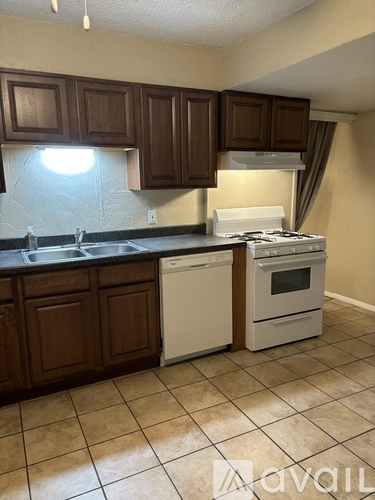 A kitchen with brown cabinets and white appliances.