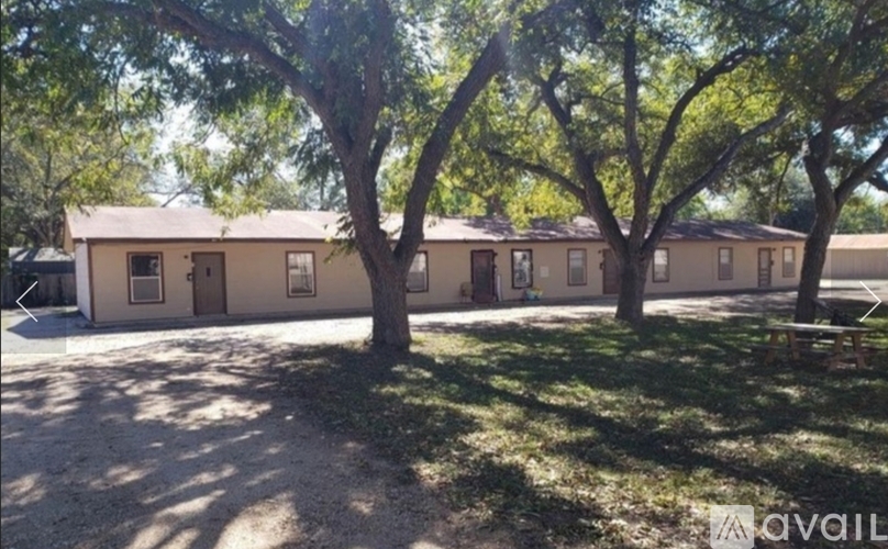 A row of houses with trees in front.