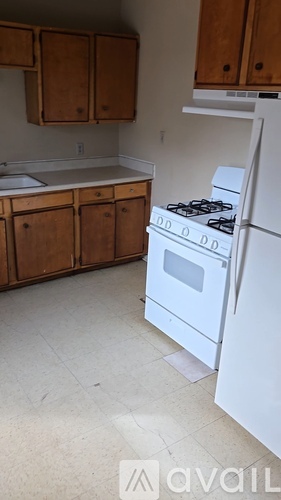A kitchen with a white refrigerator and a white stove top oven.