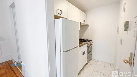 A kitchen with a white fridge and a white door.