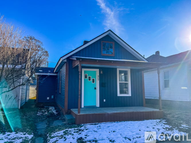 A blue house with a white door and windows.