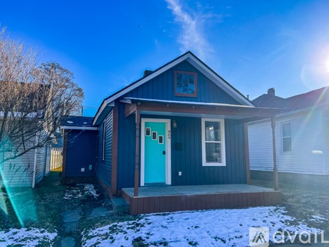 A blue house with a white door and windows.
