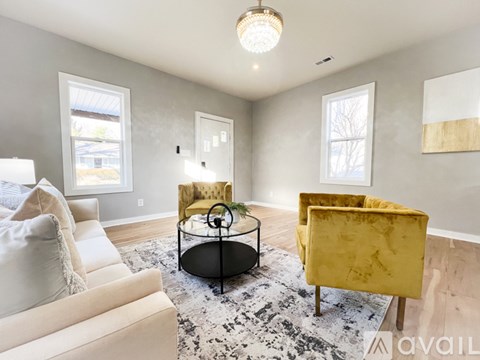 A living room with a yellow chair and a glass table.