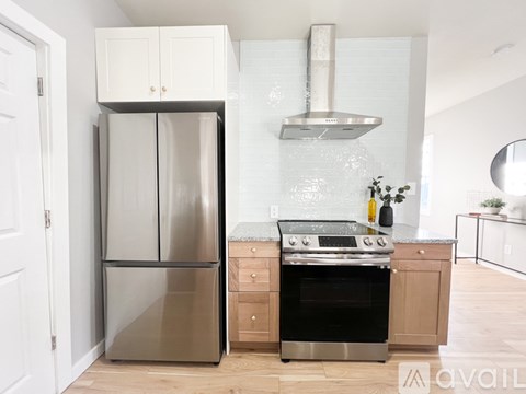 A modern kitchen with a stainless steel refrigerator and oven.