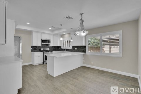 A modern kitchen with white cabinets and a large island.