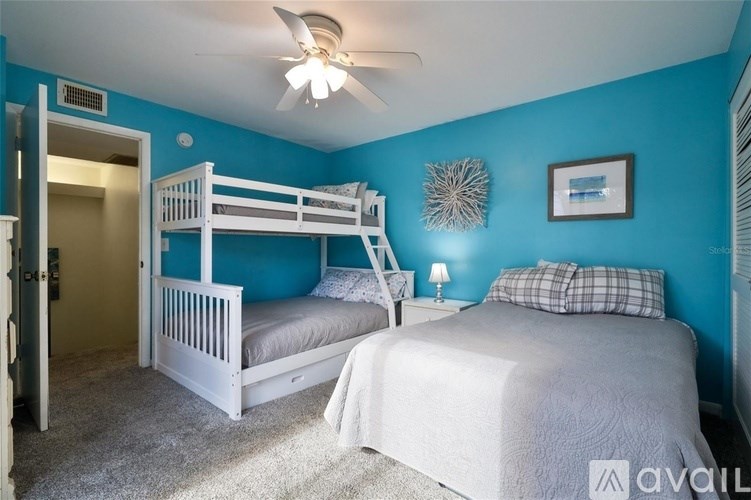 A bedroom with two beds and a ceiling fan.