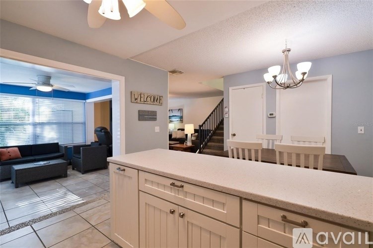 A living room with a kitchen area in the background.