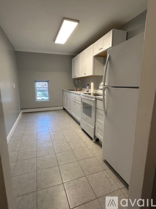 A kitchen with white appliances and cabinets.