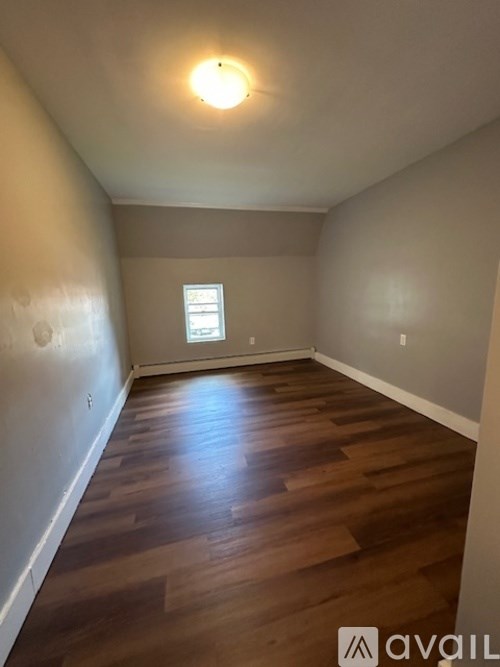 A room with wooden flooring and a window.