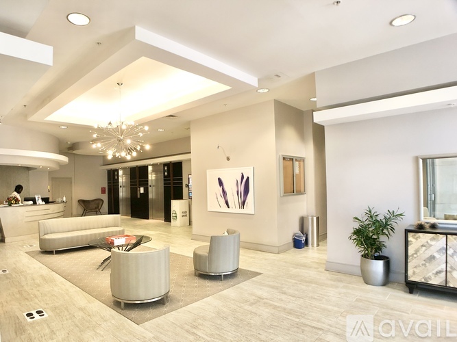 A spacious lobby with a reception desk and a large abstract painting on the wall.