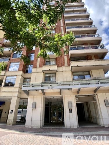 A tall building with a balcony on the second floor from the front.