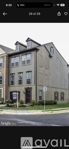 A grey building with a brown door and windows.