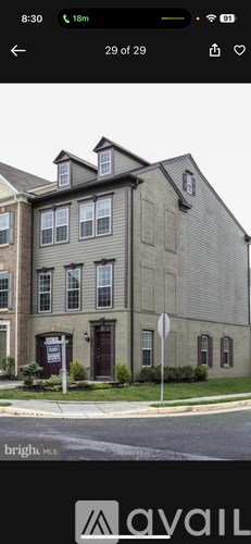 A grey building with a brown door and windows.