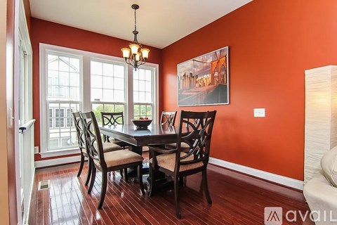 A dining room with a wooden table and chairs.