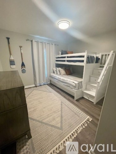 A room with a bunk bed and a rug on the floor.