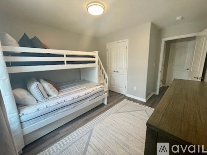 A bedroom with a bunk bed and a wooden table.