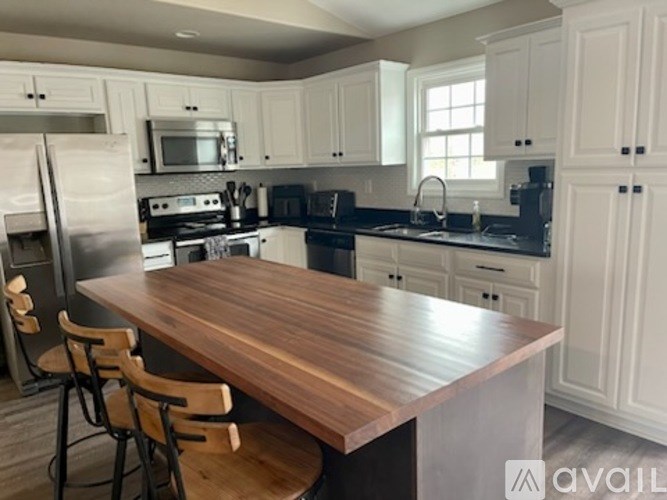 A kitchen with a wooden table and white cabinets.