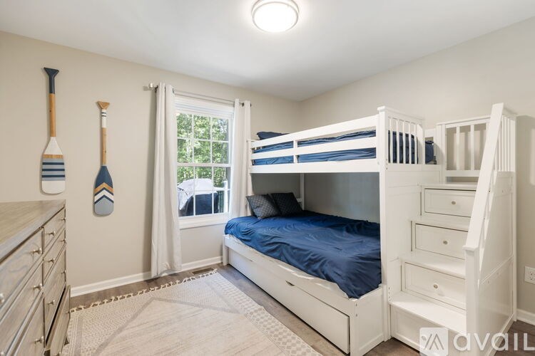 A bedroom with a bed, nightstand, and a fan.
